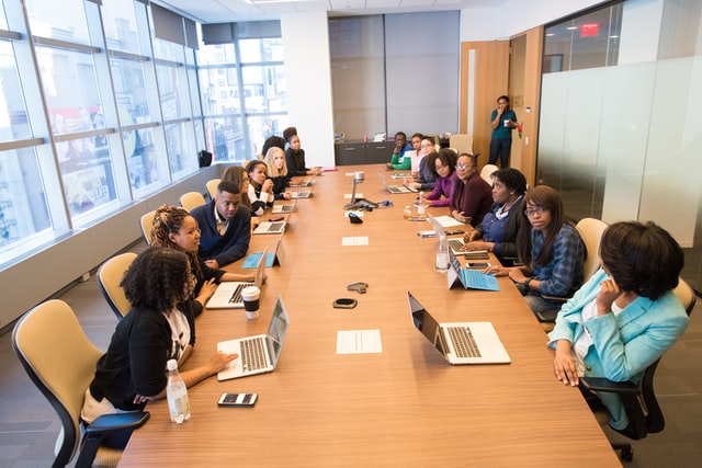 conference room full of managers and employees within a meeting